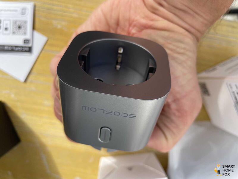 Die EcoFlow Smart Plug, smarte Steckdose wird in der Hand gehalten.